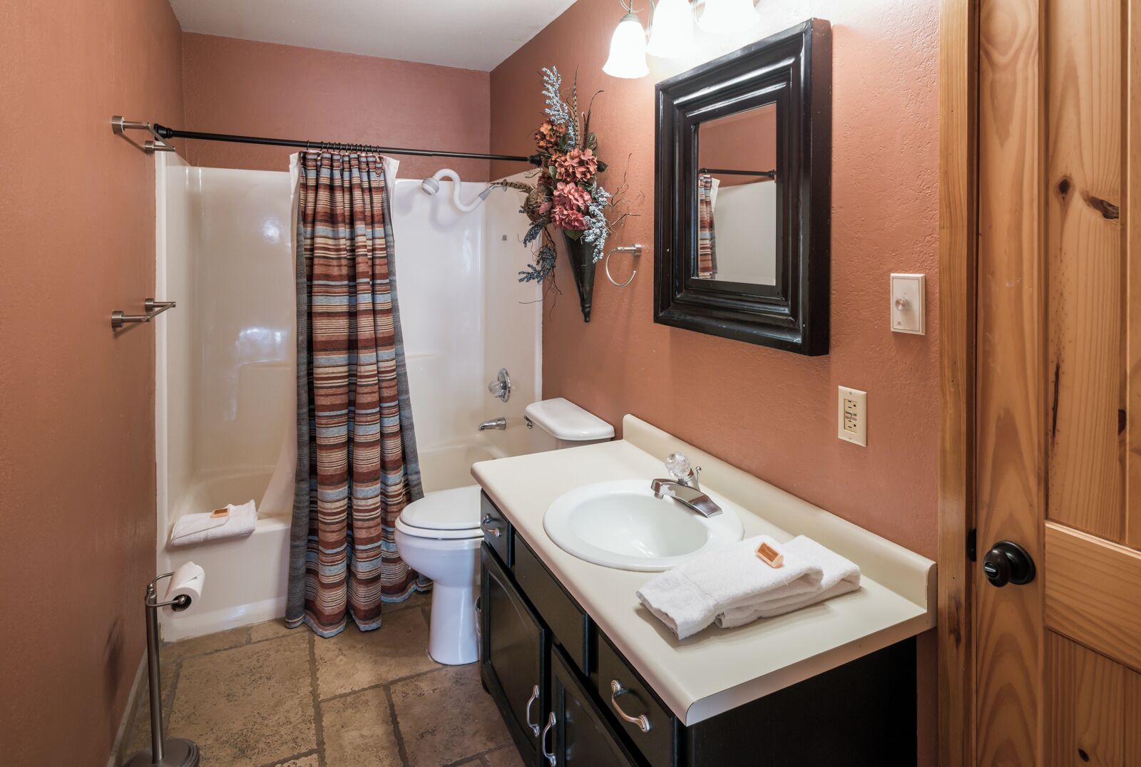 Une salle de bain équipée d’une douche, de toilettes, d’un lavabo et d’un miroir.