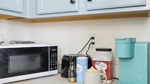 A kitchen with a microwave, toaster, coffee maker, and a jar of sugar. - Cozy Home for Entire Family (Charlotte)