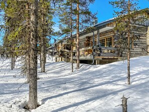 Une cabane en rondins avec une piste de ski en arrière-plan.