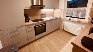Una cocina moderna con horno integrado, estufa y lavamanos.