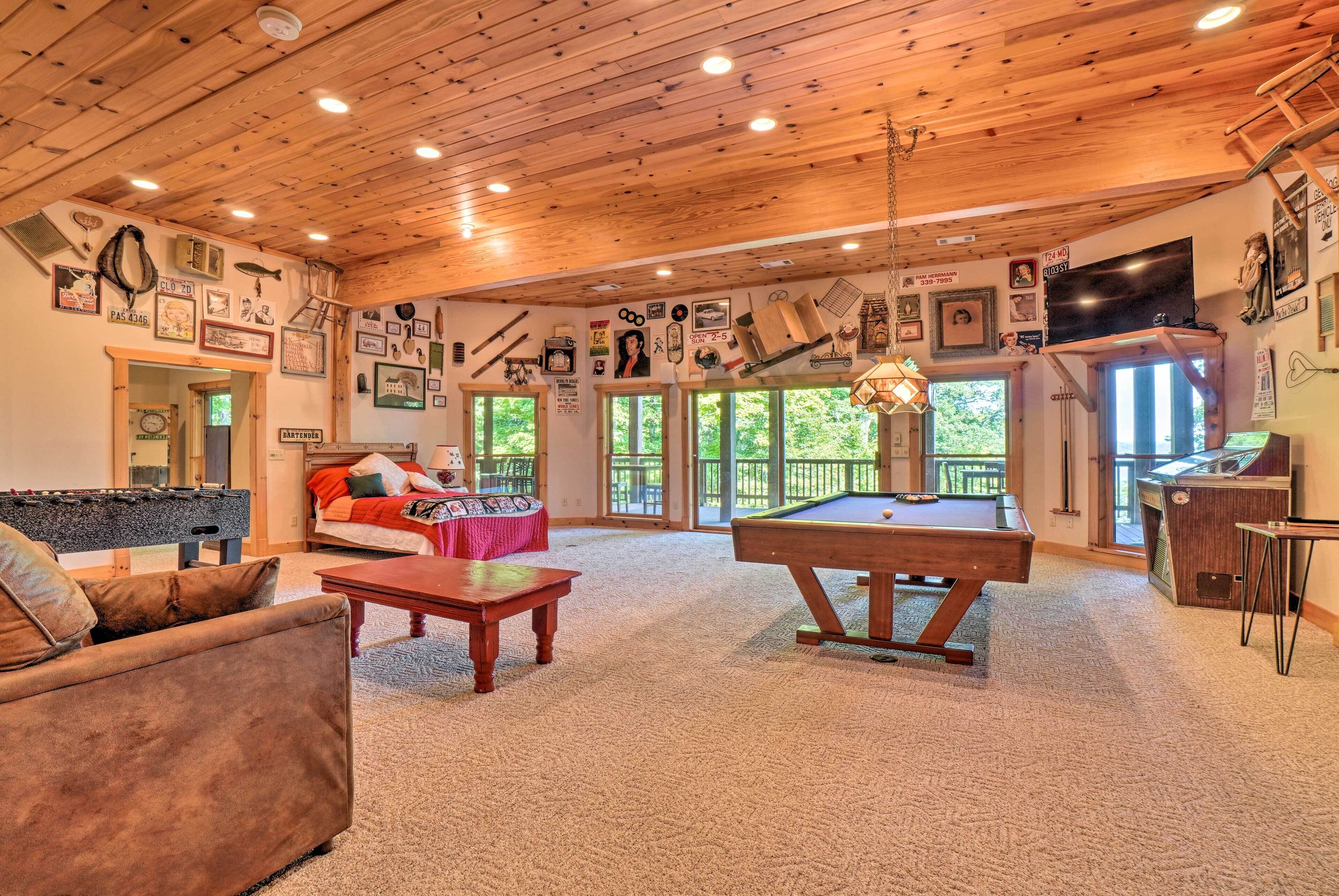 A cozy living room with a pool table, a sofa, and a billiards table.