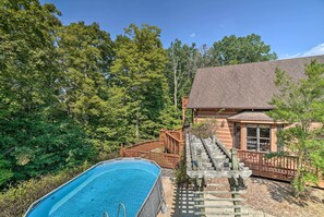 Relax by the serene pool surrounded by lush greenery and a charming cabin.