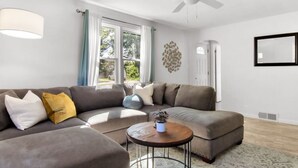 A modern living room with a sectional sofa, a round coffee table, and a ceiling fan. - Esser · 4Bed Charmer in Central Washington/East Peoria (Washington)