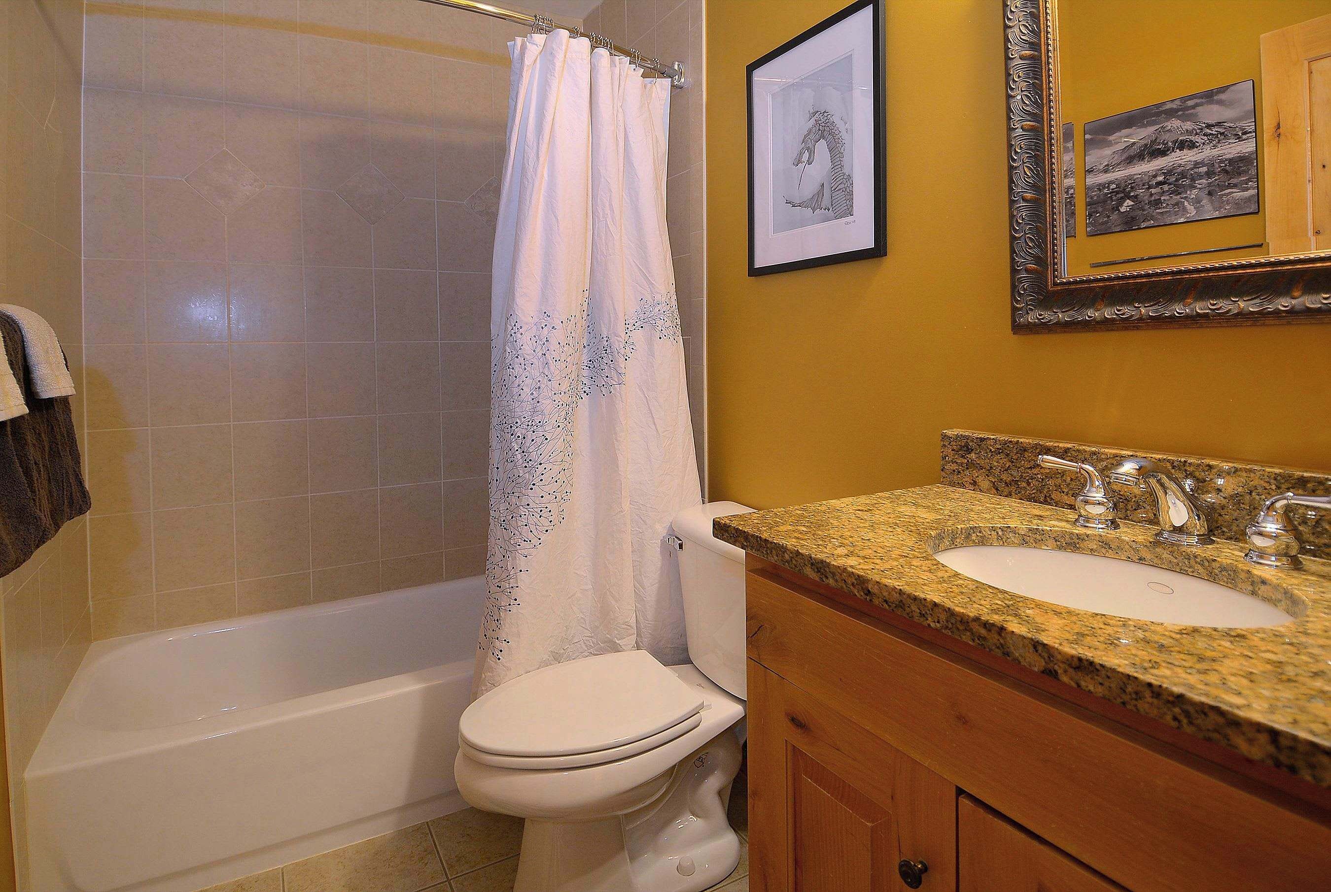 A bathroom with a bathtub, toilet, and sink.