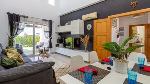 Un salon moderne avec un canapé, une table à manger et un téléviseur.