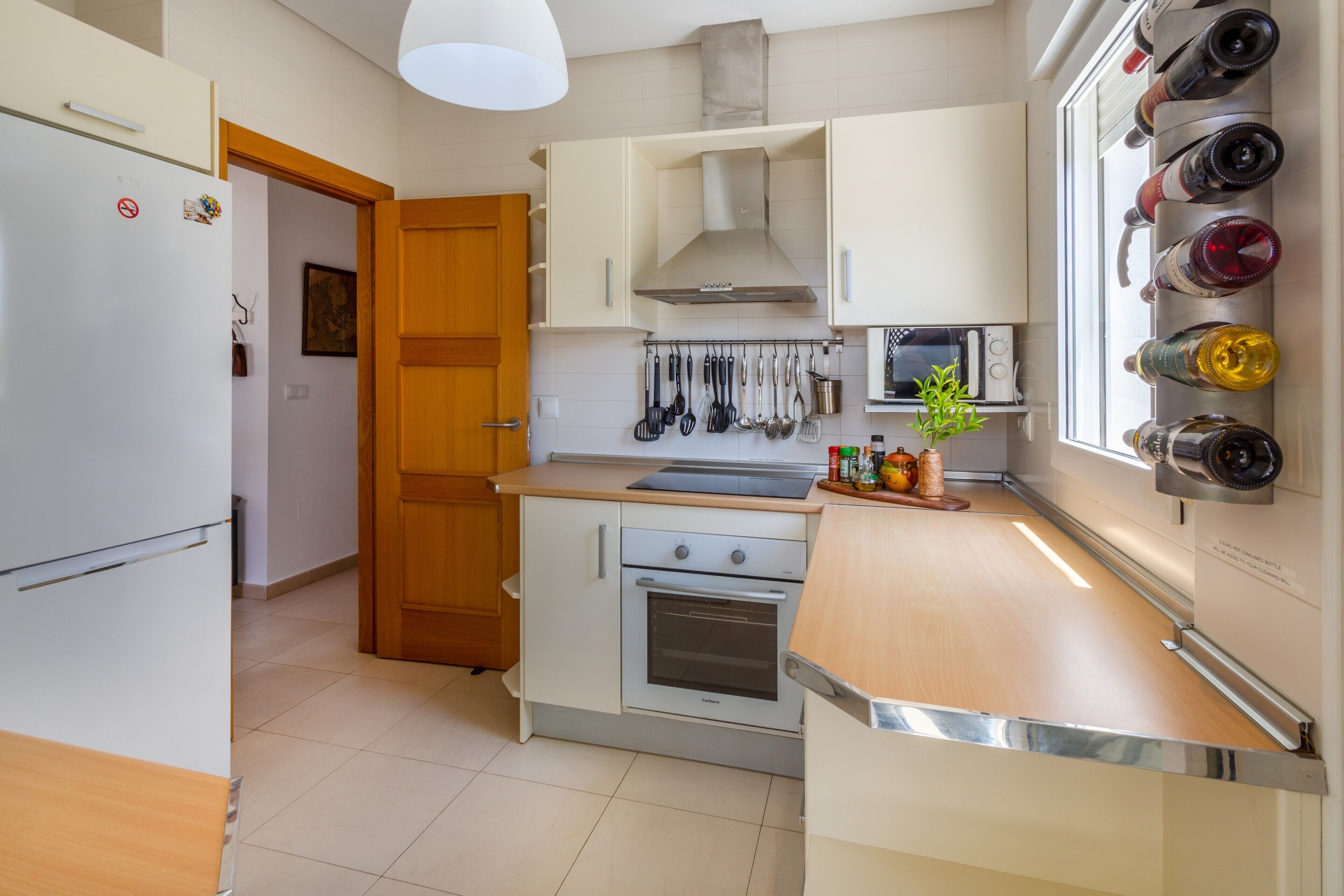 Una cocina moderna con horno empotrado, microondas y espacio para vinos.
