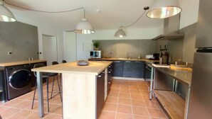 A modern kitchen with a central island, stainless steel appliances, and pendant lighting.