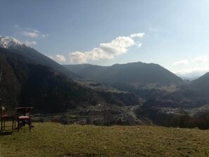 Eine gebirgige Landschaft mit einem Tal und einem Stuhl im Vordergrund.