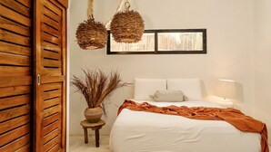 A bedroom with a bed, a nightstand, a lamp, a window, and a wall-mounted shelf. - Awesome jungle villa with pool La Veleta (Tulum)