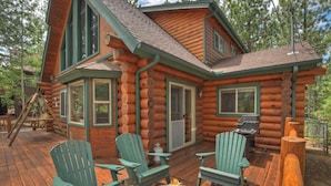 A log cabin with a deck, outdoor seating, and a fire pit. - Red Cloud Cottage: Luxury Log Cabin Walking Distance to Snow Summit! Hot Tub! Game Room! Pet Friendly! EV Charger! (Big Bear Lake)