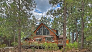 A log cabin surrounded by trees. - Red Cloud Cottage: Luxury Log Cabin Walking Distance to Snow Summit! Hot Tub! Game Room! Pet Friendly! EV Charger! (Big Bear Lake)