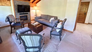 Una sala acogedora con chimenea, un sofá, una mesa de centro y un televisor.