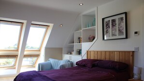 Une chambre à coucher comprenant un lit, une table de chevet, une étagère avec des objets décoratifs et une fenêtre.
