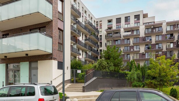 A multi-story residential building with balconies, a staircase, and a gated entrance. - Modern Studio with Balcony | Close to Arkadia Shopping Center (Warszawa)