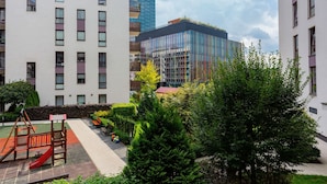 A residential building with a playground, green spaces, and modern architecture. - Modern Studio with Balcony | Close to Arkadia Shopping Center (Warszawa)