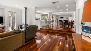 A spacious living area with a sofa, a fireplace, and a dining area with chairs and a table. - Tumby on Rye (Rye)