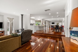 A spacious living area with a sofa, a fireplace, and a dining area with chairs and a table. - Tumby on Rye (Rye)