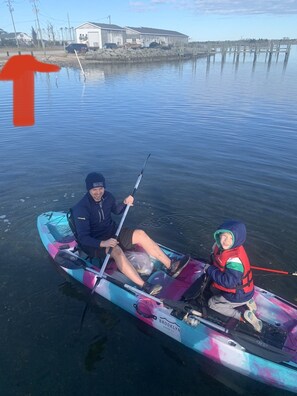 A kayak on calm water with a dock in the background. - Water View & Access, Game Room~Sunrise~Beach~Kayak Fishing Sleeps 6 (Smyrna)