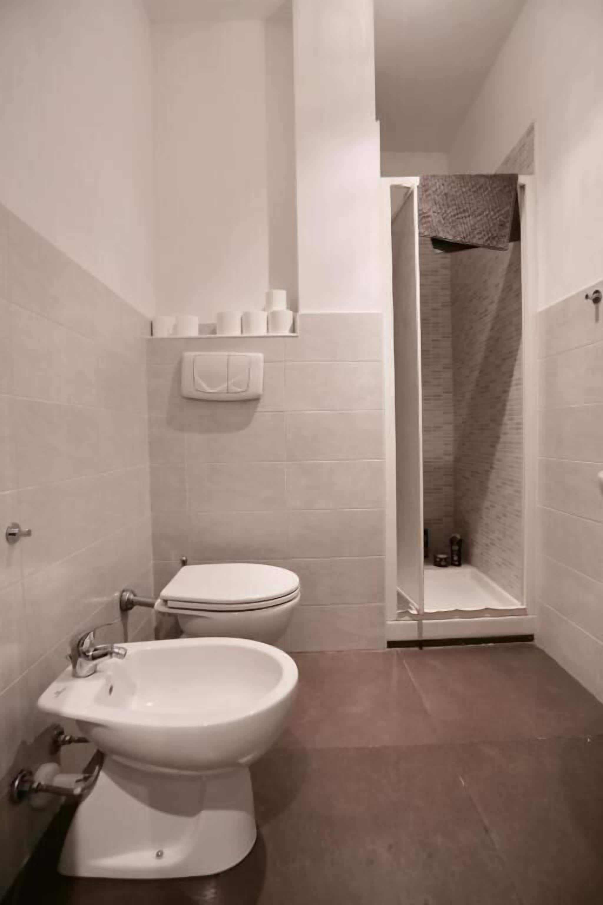 A modern bathroom with a toilet, bidet, and shower.