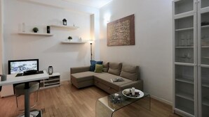 Uma sala de estar moderna com um sofá seccional, uma mesa de centro de vidro e prateleiras embutidas.