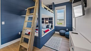 A room with a bunk bed, a ladder, a window, a white desk, and a patterned rug. - Private Home with Custom Pool and Spa! (Bradenton Beach)