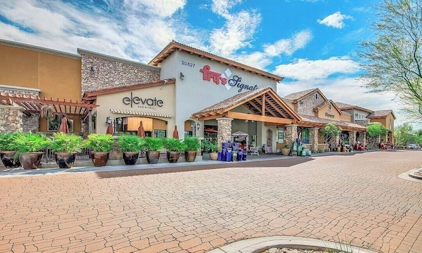 A building with a sign for 'elevate BAR & GRILL' and 'Fit's Signat'.
