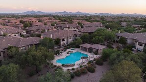 Zona residencial con piscina, rodeada de casas y vegetación.