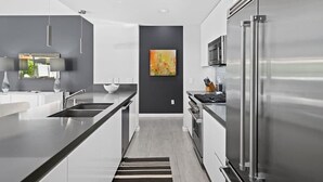 Eine moderne Küche mit einem Edelstahl-Kühlschrank, einer Mikrowelle und einem Spülbecken.