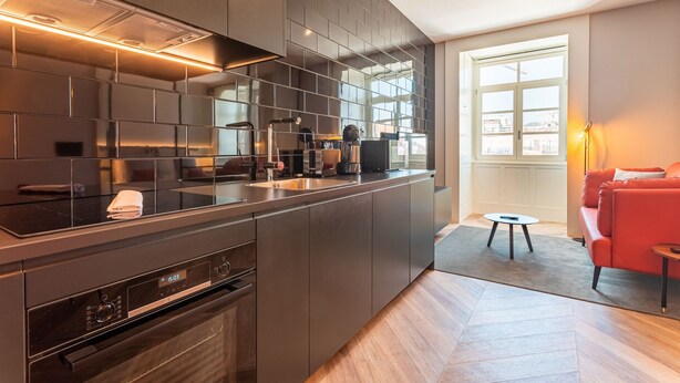 A modern kitchen with dark cabinetry, a built-in oven, and a digital clock displaying 15:03. - FLH Viola Market Flat I (Funchal)