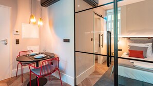 A modern hotel room with a glass partition separating the living area from the bedroom. - FLH Viola Market Flat IV (Funchal)
