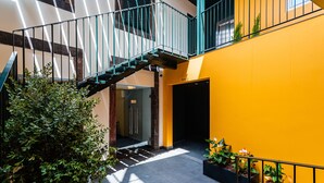 A multi-level interior with a staircase, potted plants, and a yellow wall. - FLH Viola Market Flat IV (Funchal)