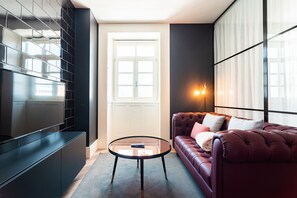 A modern living room with a glass coffee table, a leather sofa, and a large window. - FLH Viola Market Flat VI (Funchal)