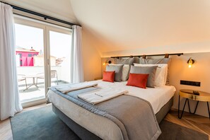 A modern hotel room with a large bed, a small round table, and a balcony with a table and chairs. - FLH Viola Market with Terrace I (Funchal)