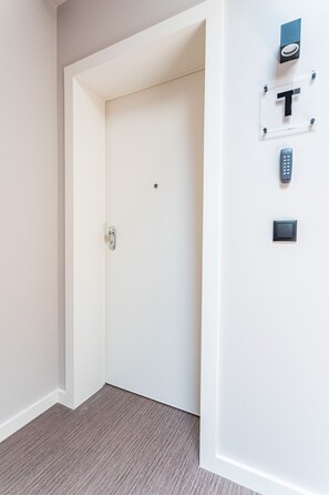A white door with a keyhole, a wall-mounted intercom, and a doorbell. - FLH Viola Market with Terrace II (Funchal)