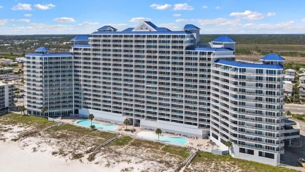 Un hotel de varios pisos con piscina y acceso a la playa.