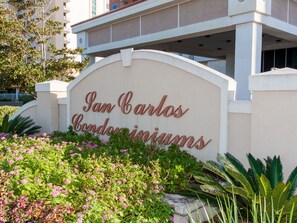 «San Carlos Condominiums» -niminen asuinalue, jonka edessä on maisemoitu alue.