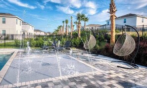 A water feature with multiple fountains, surrounded by a paved area with a checkered pattern. - Encore Resort 11 Bedroom Home with Pool (2117) (Kissimmee)