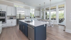 Una cocina moderna con armarios blancos, electrodomésticos de acero inoxidable y una isla grande.
