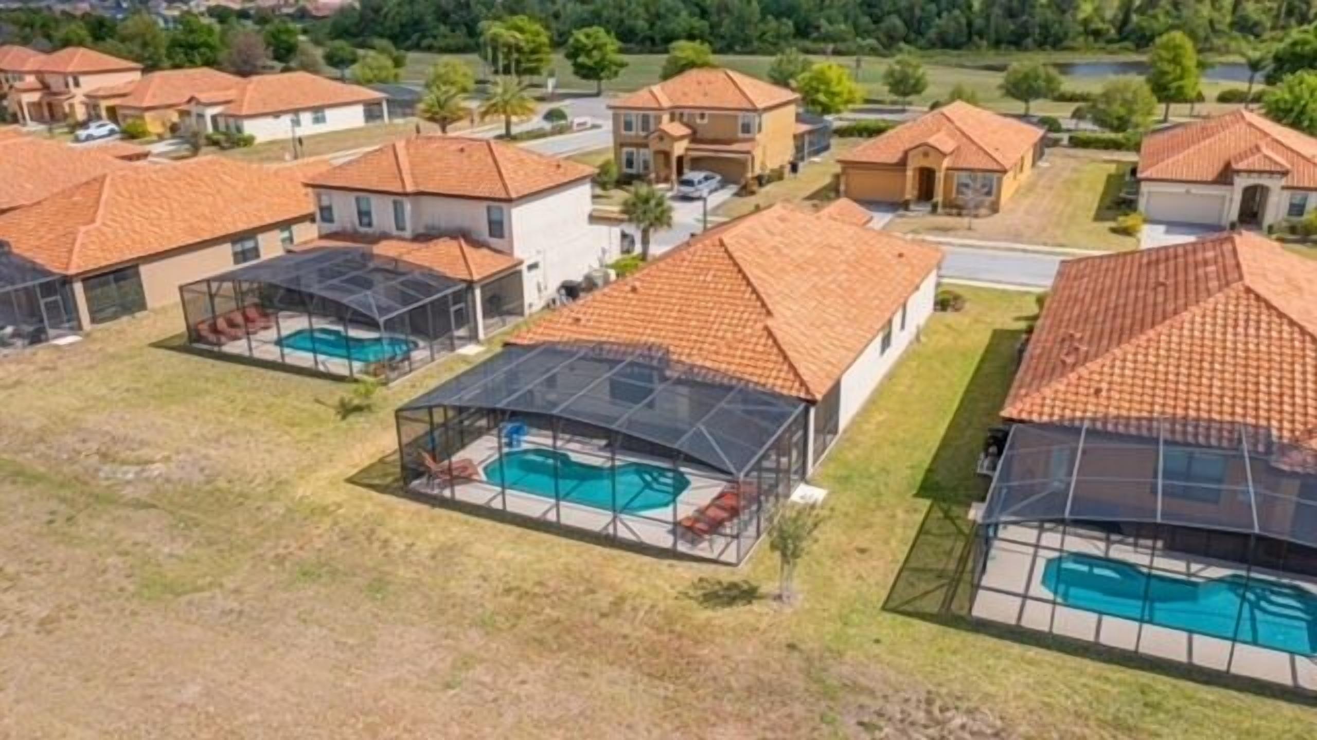 Un quartier résidentiel où les maisons sont dotées de toits en tuiles et de piscines.