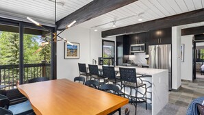Una cocina moderna con armarios oscuros, electrodomésticos de acero inoxidable y una isla grande.
