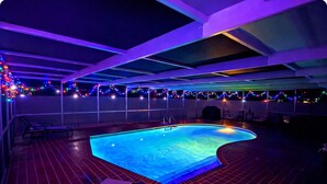 A swimming pool with a curved edge, surrounded by a tiled deck and lounge chairs. - Paradise Palms Beach house with HEATED POOL🏖🌅🐬 (Largo)