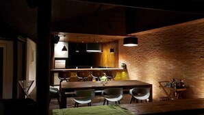 Una cocina moderna con pared de ladrillo, encimera de madera e iluminación colgante.