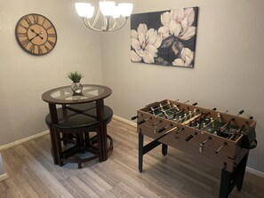 Enjoy a game of foosball or dine in style with a round table and a potted plant.