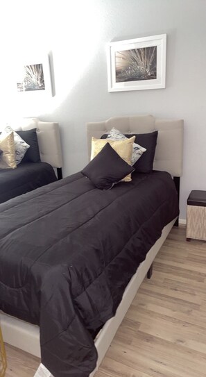 Restful retreat with a large bed, framed artwork, and a bedside table.