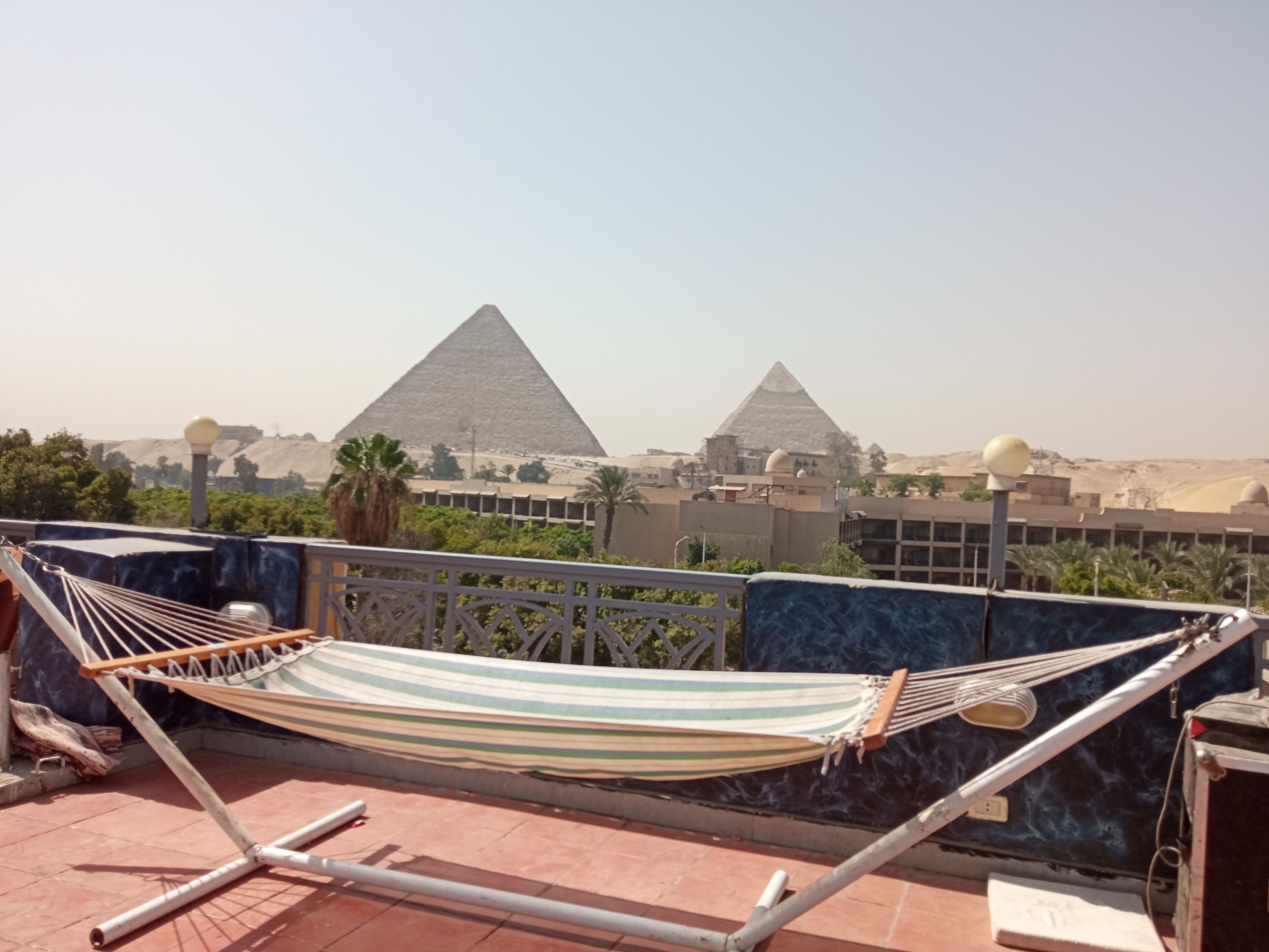Una hamaca en una terraza en la azotea con vistas a las pirámides al fondo.