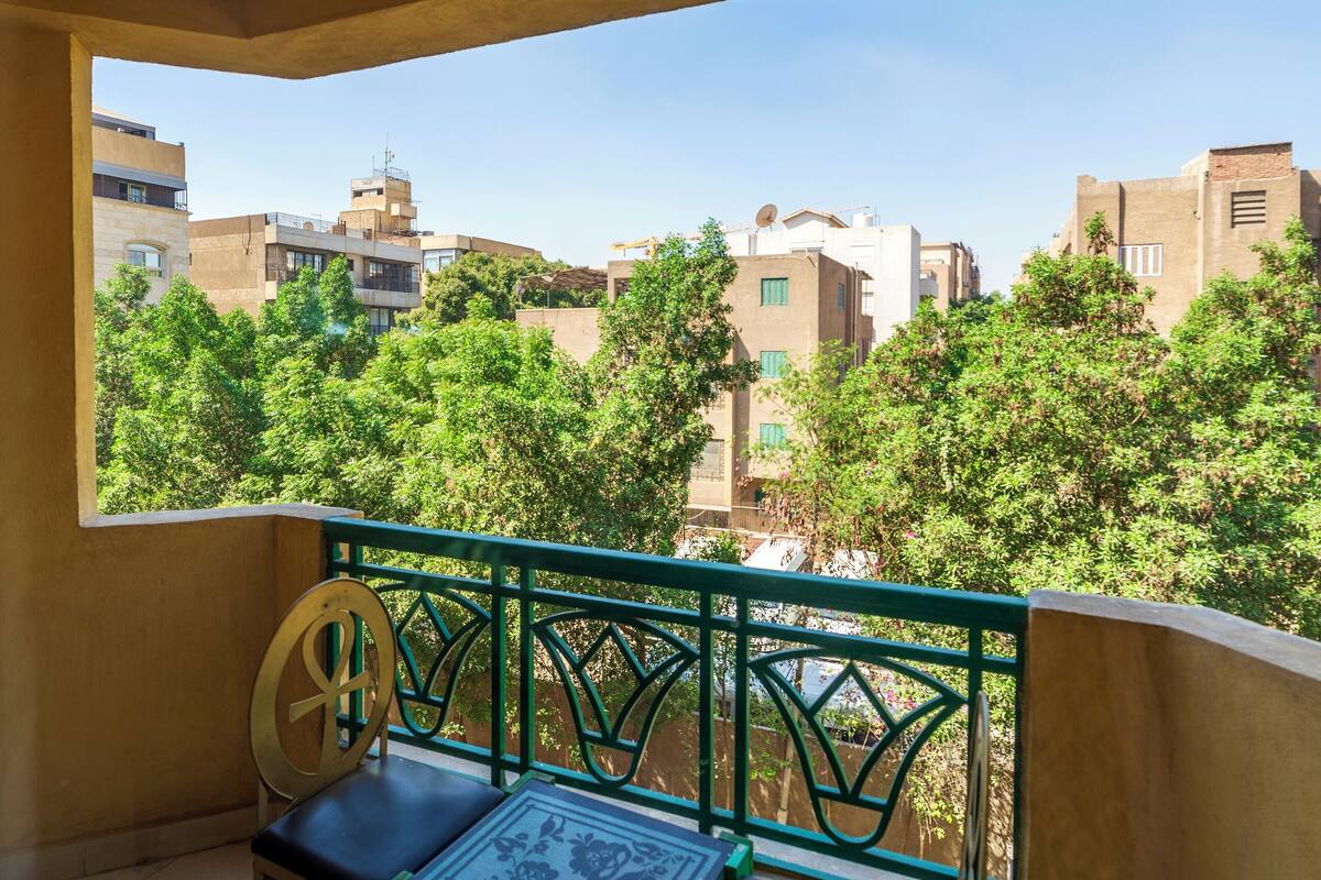 A balcony with a view of buildings and trees.