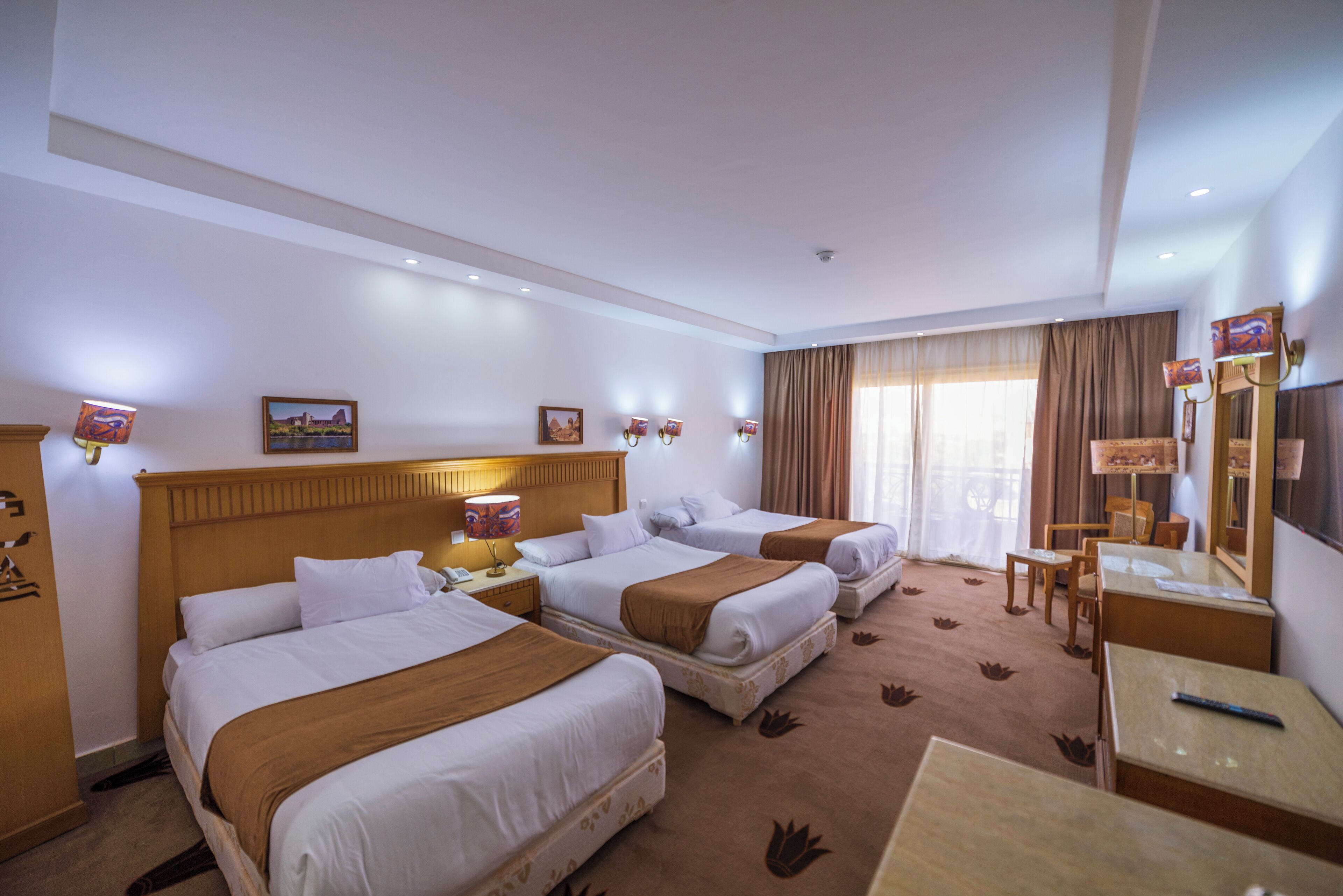 Ein Hotelzimmer mit zwei Betten, einem Schreibtisch, einem Stuhl und einem Fernseher.