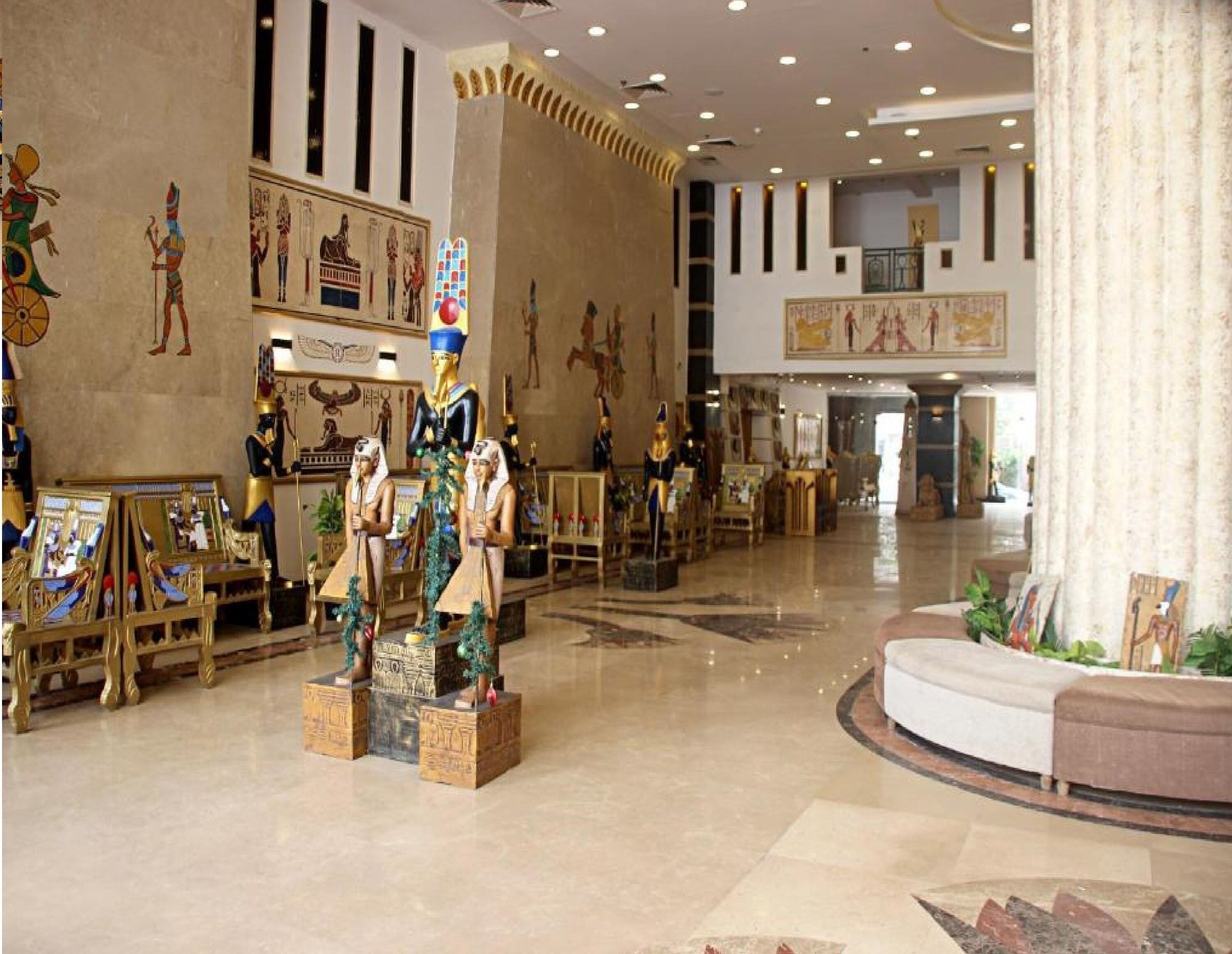 A spacious lobby with Egyptian-themed decor, including statues and wall art.