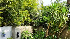 A patio with outdoor furniture, potted plants, and a stone wall. - Apartamento Lurra Barrika (Barrika)