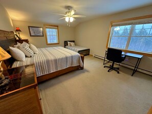 Enjoy a restful stay with a large bed, a smaller bed, and a desk with a chair.